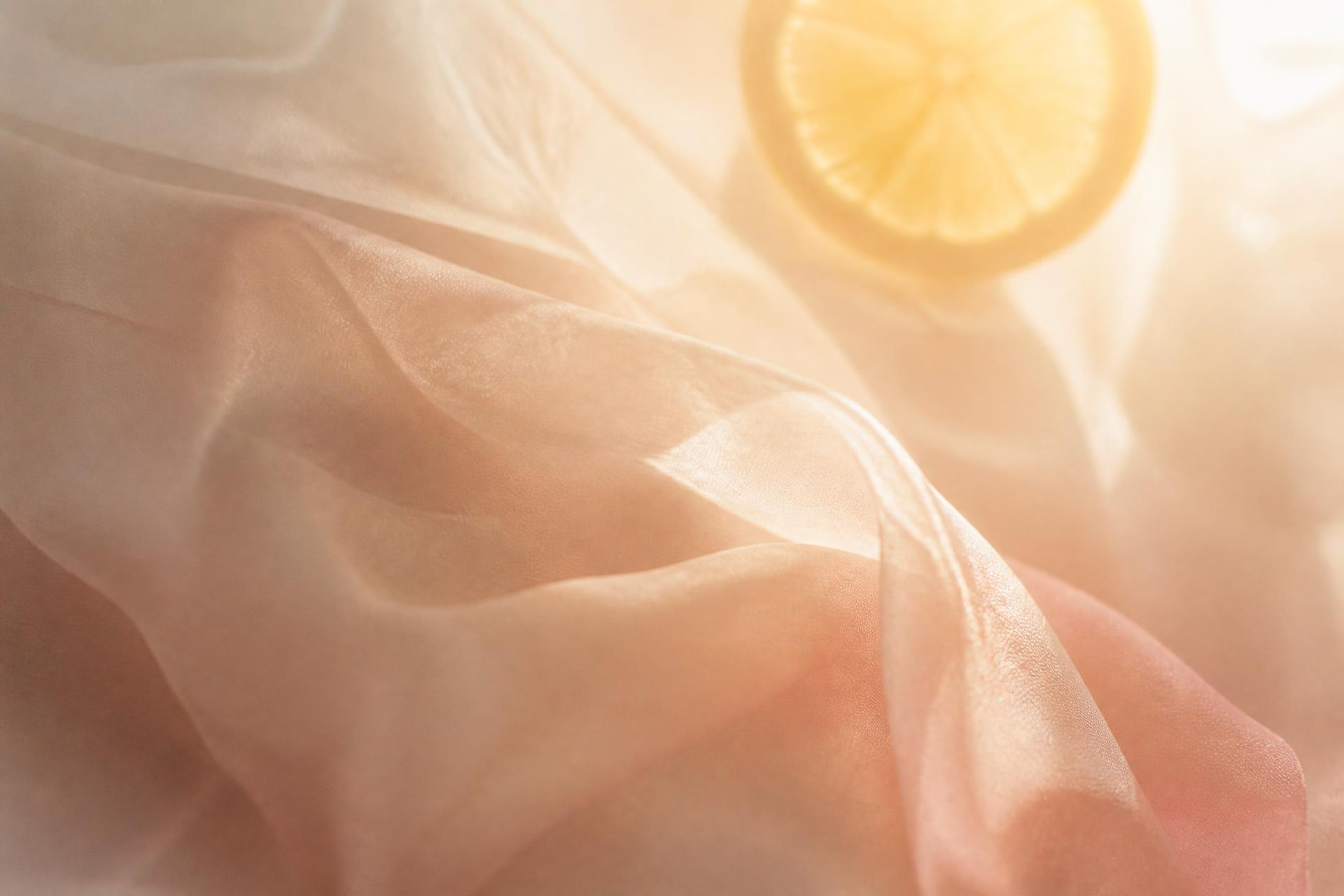 Soft morning light falling across warm cream and blush silk